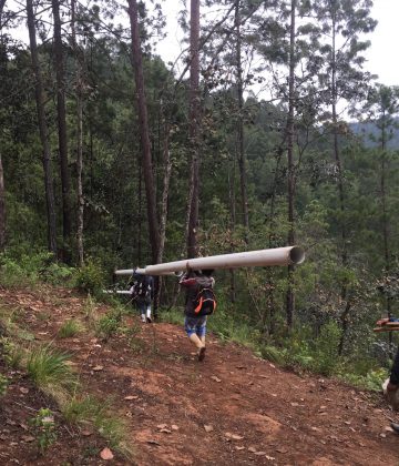 Carrying long water pipes throughout the hillside